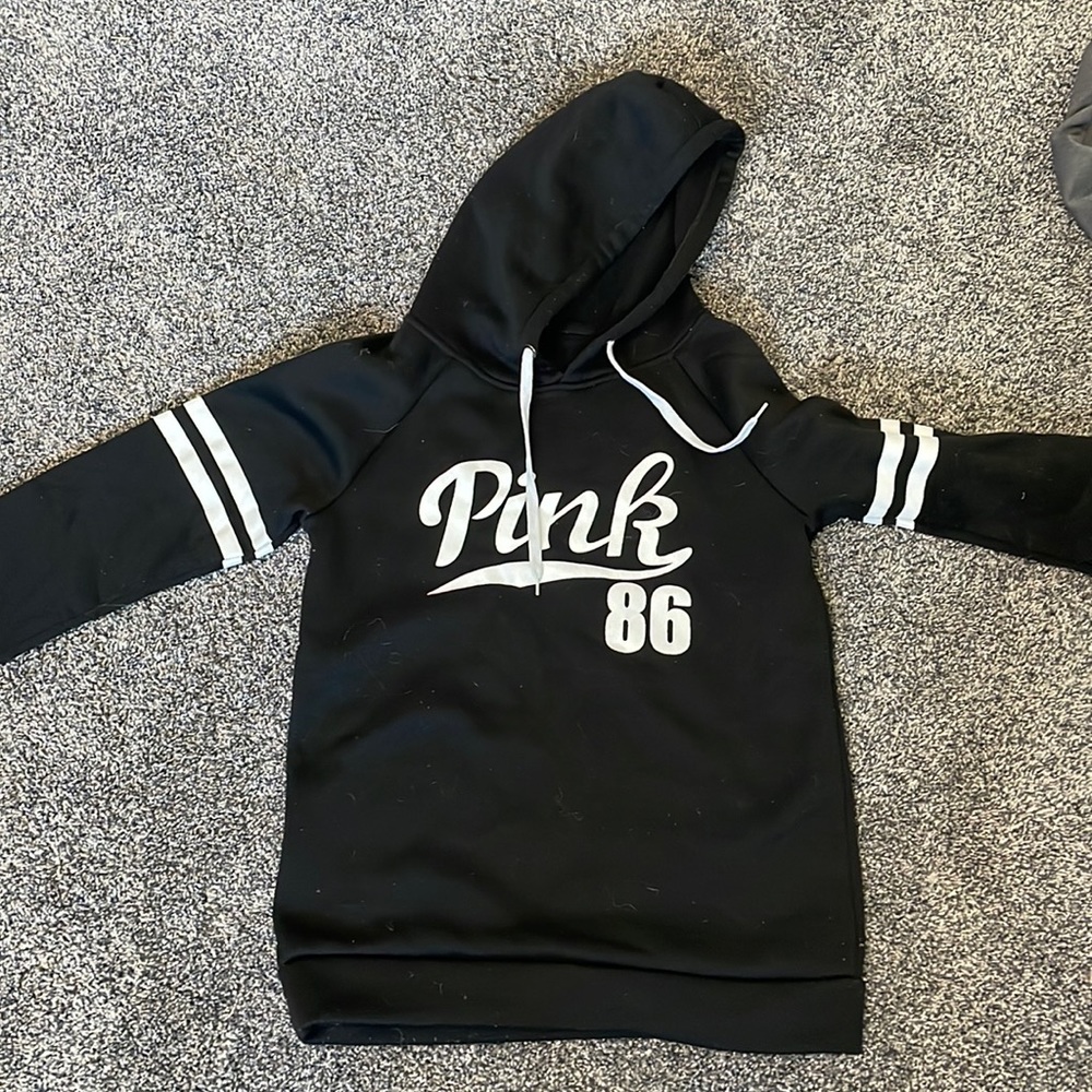 Pink hoodie, no pocket. Size small. Black with white lines/word.